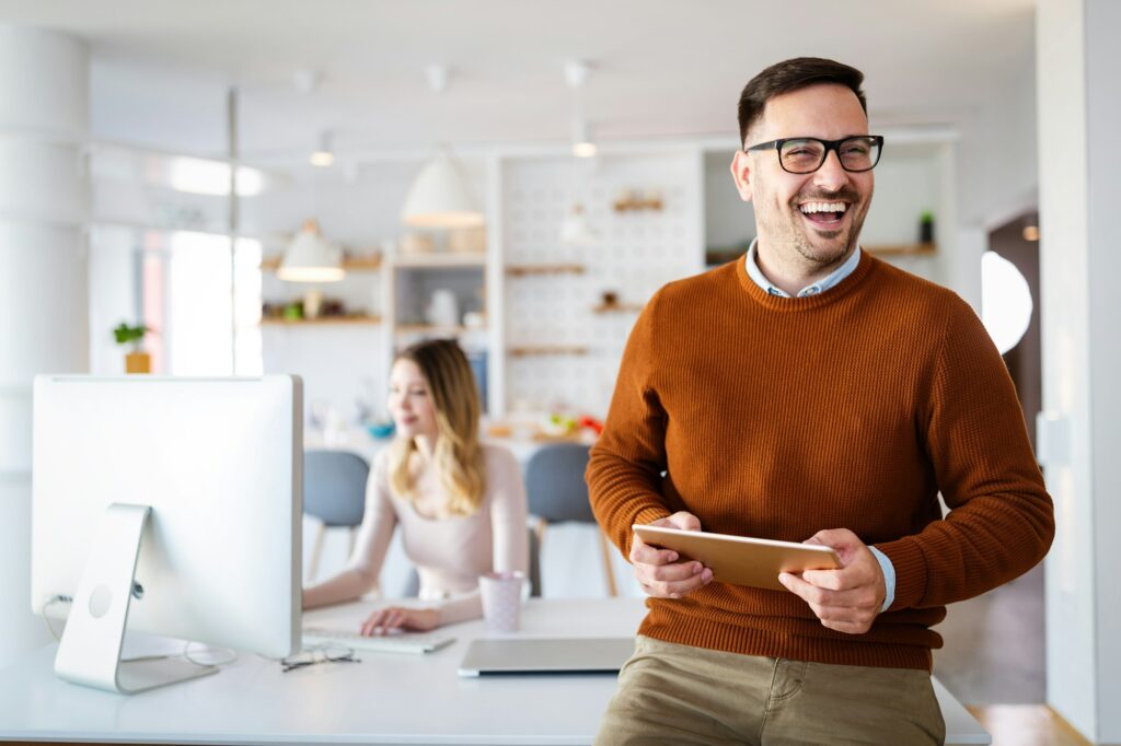 Handsome businessman using tablet in office. Technology, business, people concept